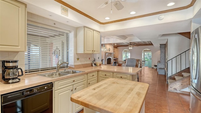 kitchen featuring a peninsula, a sink, black dishwasher, open floor plan, and decorative backsplash