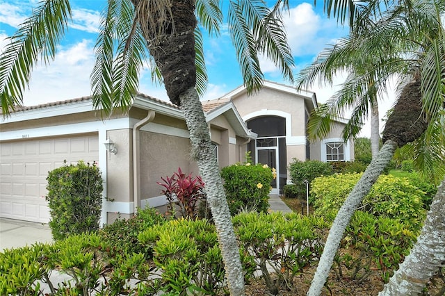 view of exterior entry featuring an attached garage and stucco siding