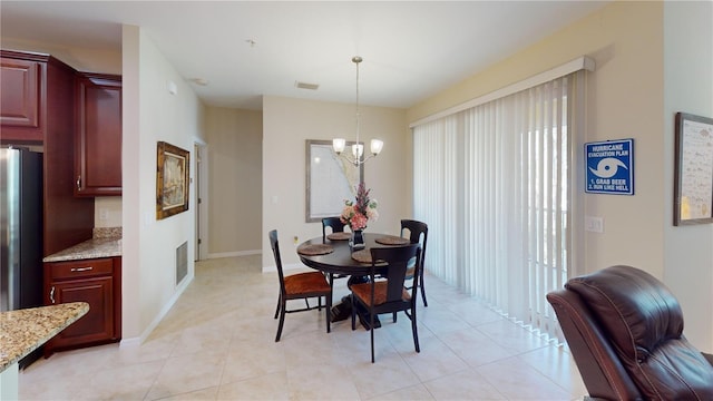 dining area featuring baseboards, light tile patterned flooring, visible vents, and a notable chandelier