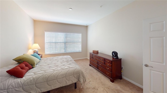 bedroom with light carpet and baseboards