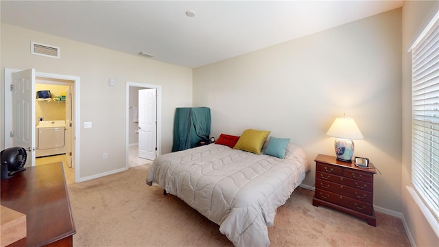 bedroom with light carpet, baseboards, visible vents, and washing machine and clothes dryer