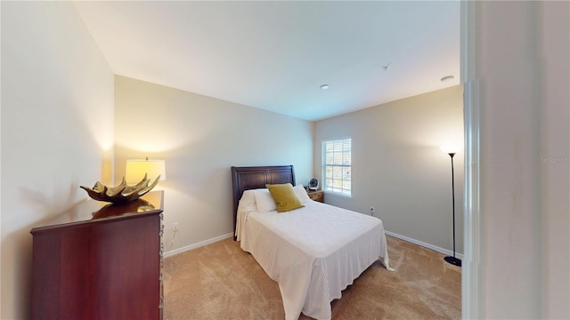 bedroom featuring light carpet and baseboards