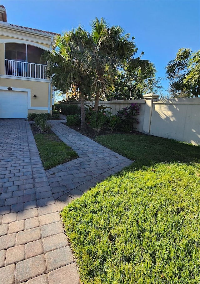 view of yard with driveway and fence