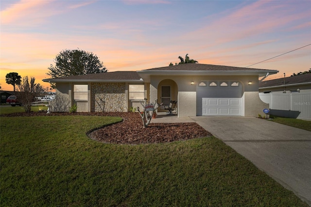 ranch-style home featuring an attached garage, fence, concrete driveway, stone siding, and a front lawn