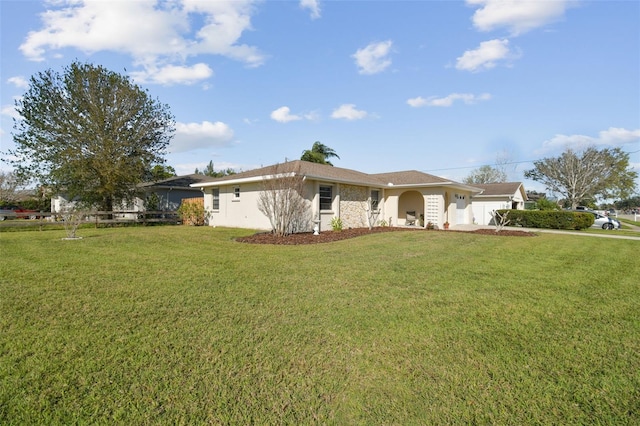 single story home featuring an attached garage, stucco siding, and a front yard