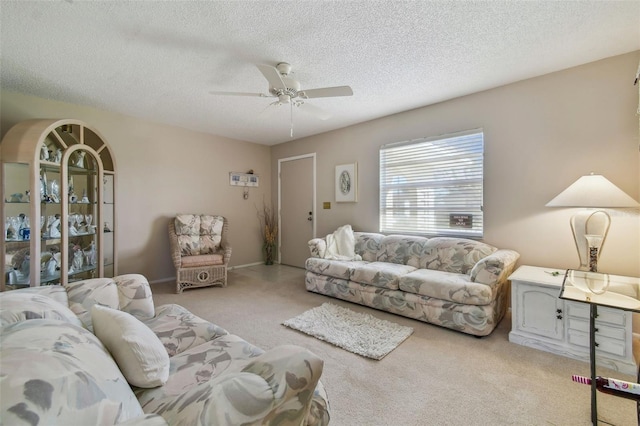 carpeted living room featuring ceiling fan and a textured ceiling