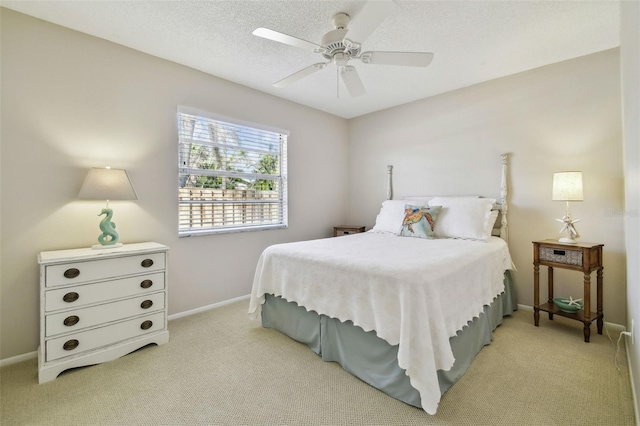 bedroom featuring a textured ceiling, light carpet, a ceiling fan, and baseboards