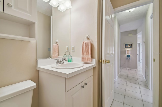 bathroom featuring visible vents, toilet, a textured ceiling, vanity, and tile patterned flooring