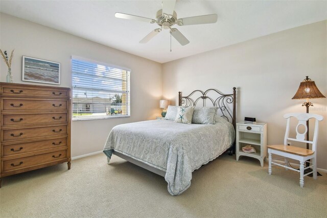 bedroom with light carpet, ceiling fan, and baseboards