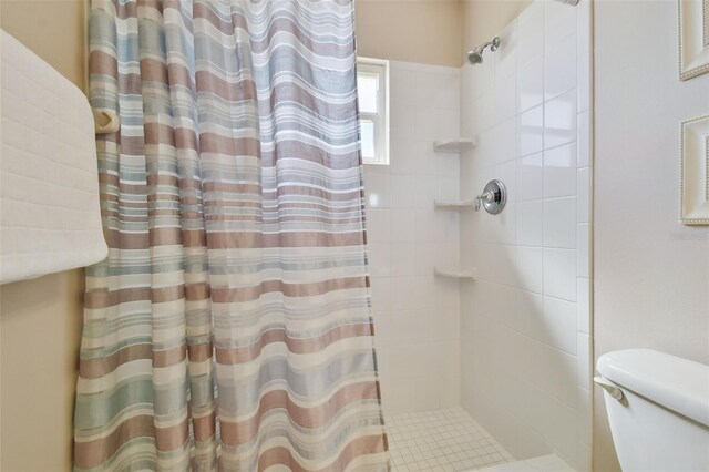 bathroom with tiled shower and toilet