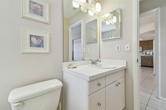 half bath featuring toilet, tile patterned flooring, and vanity