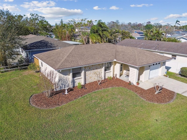 ranch-style home featuring driveway, a shingled roof, a garage, and a front yard