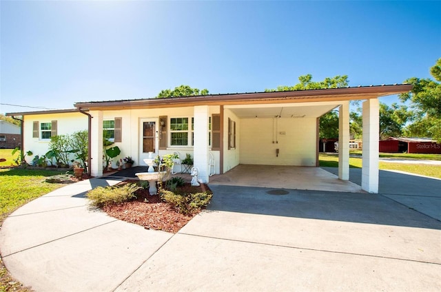 ranch-style house featuring a carport, a front lawn, and concrete driveway