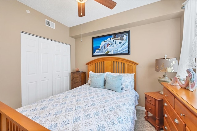 bedroom featuring a closet, visible vents, a textured ceiling, and a ceiling fan