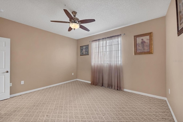 spare room featuring a textured ceiling, ceiling fan, baseboards, and light carpet