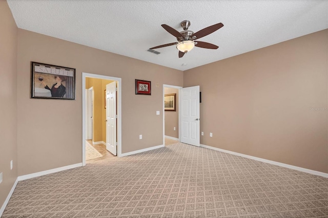 unfurnished bedroom with light colored carpet, baseboards, and a textured ceiling