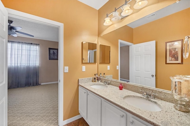 full bath featuring ceiling fan, double vanity, visible vents, and a sink