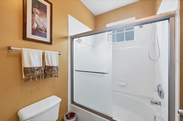 full bathroom with toilet and shower / bath combination with glass door