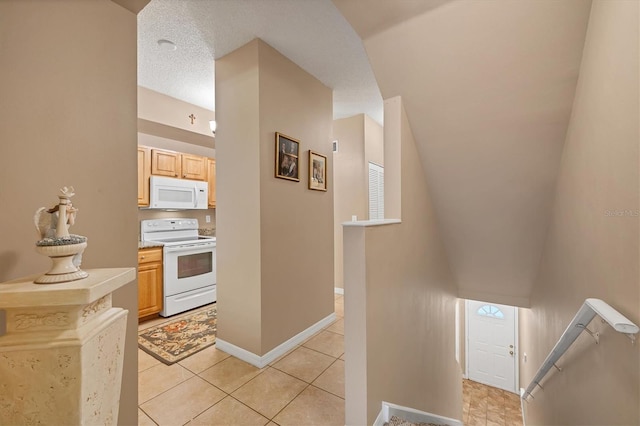 kitchen with white appliances, baseboards, lofted ceiling, light countertops, and a textured ceiling