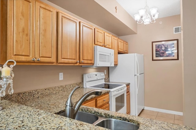 kitchen with visible vents, a sink, light stone counters, white appliances, and light tile patterned flooring