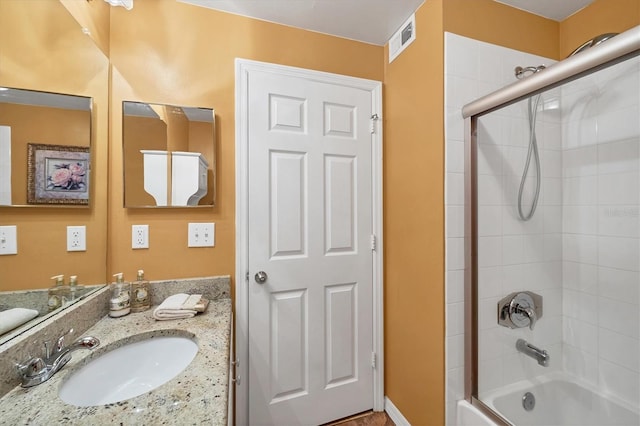 bathroom featuring visible vents, enclosed tub / shower combo, and vanity