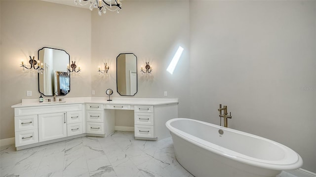 full bathroom with vanity, a soaking tub, baseboards, and marble finish floor