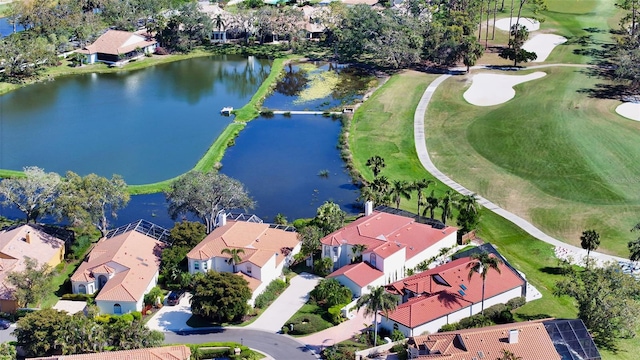 drone / aerial view with view of golf course, a residential view, and a water view