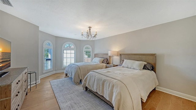 bedroom featuring light wood finished floors, visible vents, and baseboards