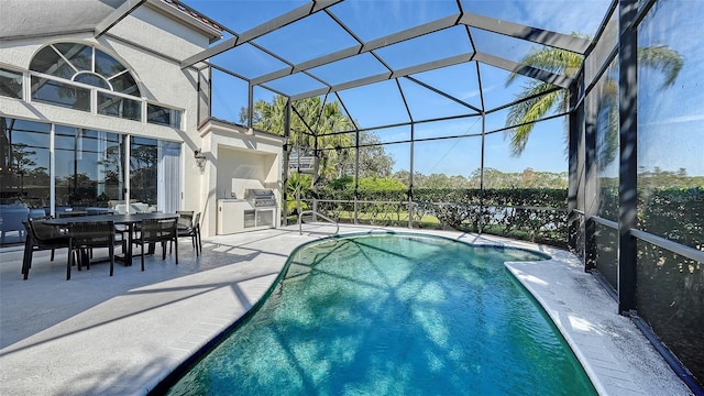 outdoor pool featuring glass enclosure, a patio, and an outdoor kitchen