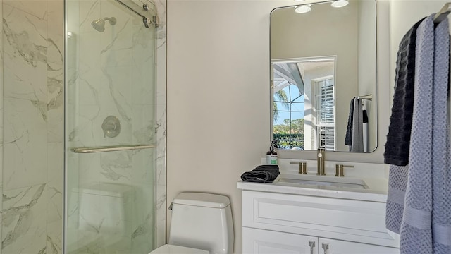 bathroom featuring a marble finish shower, toilet, and vanity