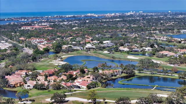 drone / aerial view with a residential view, a water view, and golf course view