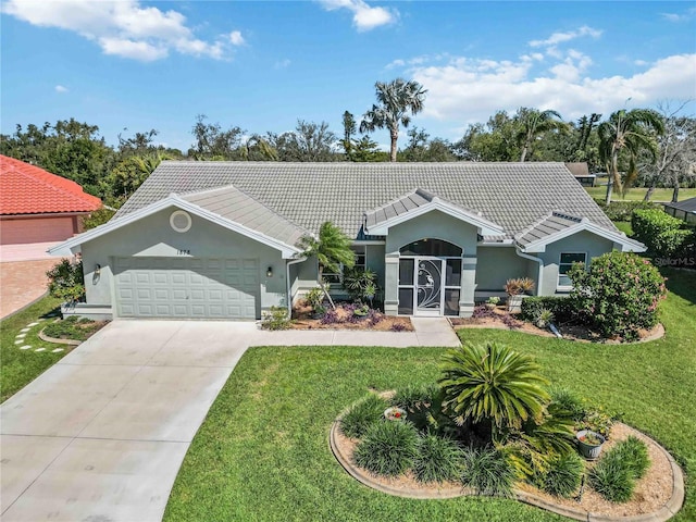 ranch-style house with an attached garage, concrete driveway, a front yard, and a tiled roof