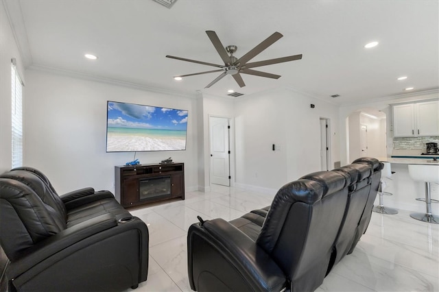 living room with crown molding, a ceiling fan, arched walkways, and marble finish floor