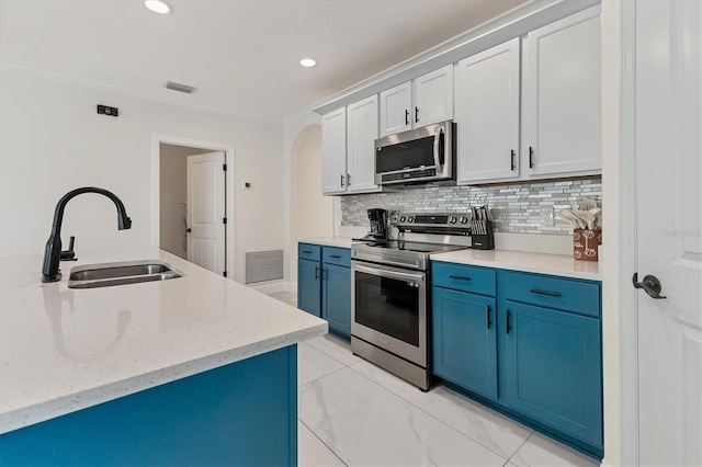 kitchen featuring visible vents, blue cabinetry, a sink, ornamental molding, and stainless steel appliances