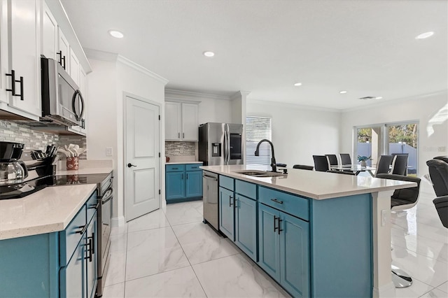 kitchen featuring crown molding, stainless steel appliances, blue cabinets, and a sink