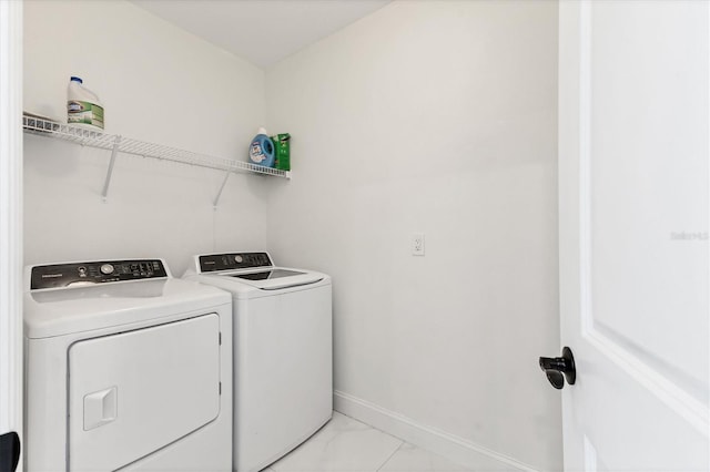 washroom featuring laundry area, baseboards, independent washer and dryer, and marble finish floor