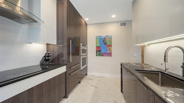 kitchen featuring marble finish floor, visible vents, a sink, modern cabinets, and wall chimney exhaust hood