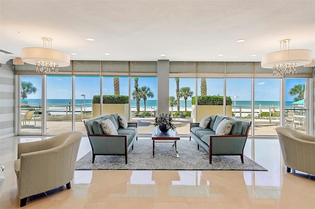 living room featuring a water view, expansive windows, light tile patterned flooring, a notable chandelier, and recessed lighting