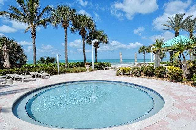 pool featuring a patio and a water view