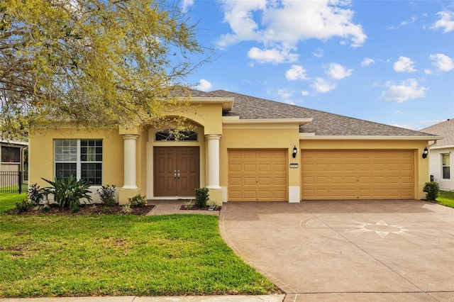 view of front of house featuring a shingled roof, concrete driveway, stucco siding, an attached garage, and a front yard