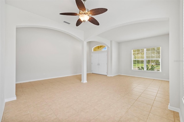 unfurnished room featuring light tile patterned floors, a ceiling fan, visible vents, and baseboards