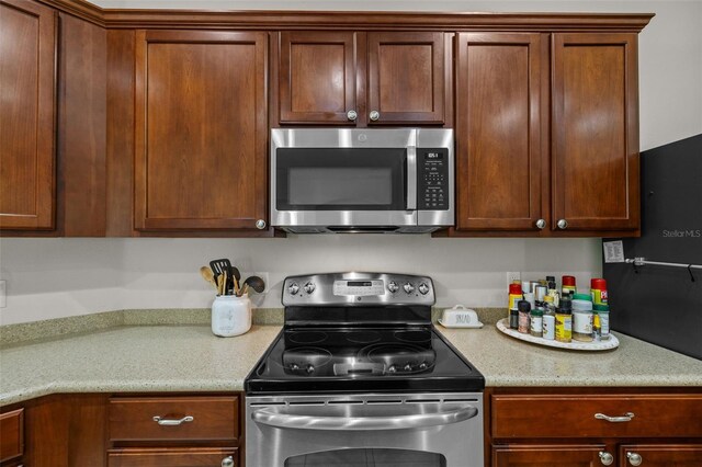 kitchen with appliances with stainless steel finishes and light stone counters