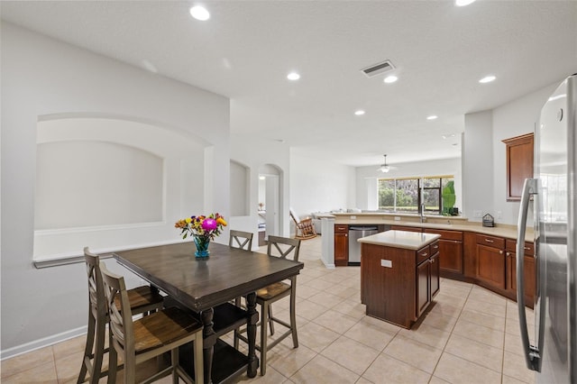 kitchen featuring visible vents, a kitchen island, a peninsula, stainless steel appliances, and light countertops