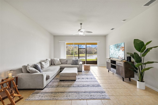 living room with ceiling fan, light tile patterned floors, visible vents, and baseboards