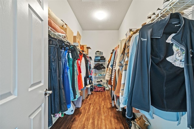 walk in closet with wood finished floors