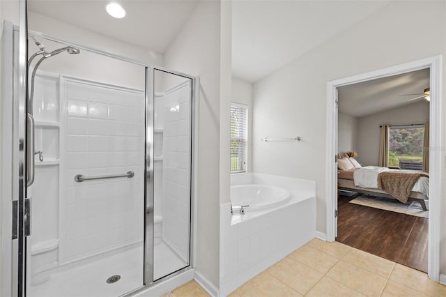 full bath featuring plenty of natural light, tile patterned flooring, vaulted ceiling, and a stall shower