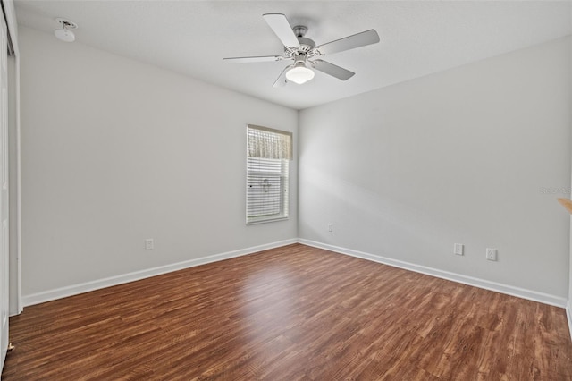 empty room featuring a ceiling fan, baseboards, and wood finished floors