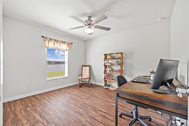 home office featuring a ceiling fan, baseboards, and wood finished floors