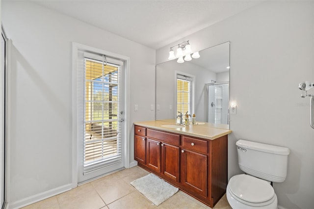 bathroom featuring tile patterned flooring, toilet, vanity, baseboards, and a stall shower