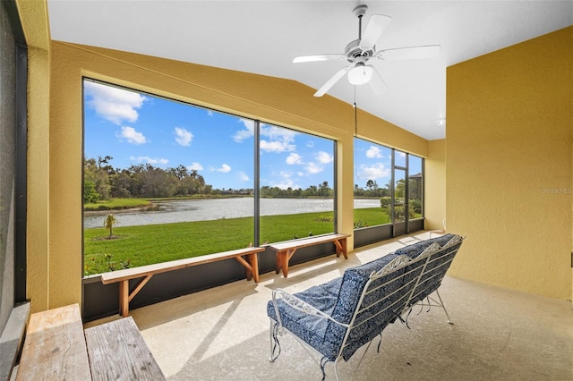 sunroom featuring a water view and ceiling fan